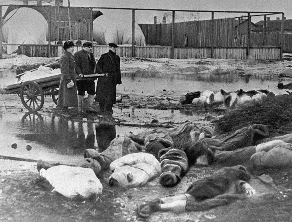 Na fotografiji su tri muškarca koja pokapaju poginule, listopad 1942. godine.
