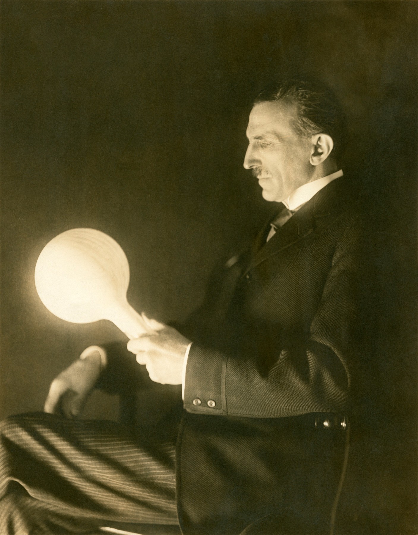 Tesla fotografiran sa svojom bežičnom žaruljom premazanom fosforom. Žarulju je izradio 1890-ih godina, otkad datira i ova fotografija.