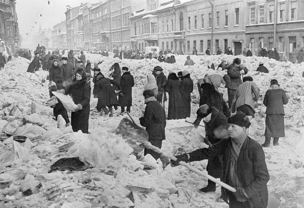 Prije same opsade građani Lenjingrada su od grada stvorili pravu utvrdu. Velik dio građana sudjelovao je u izgradnji obrambenih pojaseva. Iako su evakuacije trajale od ljeta 1941. godine, mnogi nisu željeli napustiti svoje domove. Na fotografiji je prikazano čišćenje ulica Lenjingrada, u ožujku 1942. godine, kad je grad već bio potpuno odsječen od ostatka svijeta.
