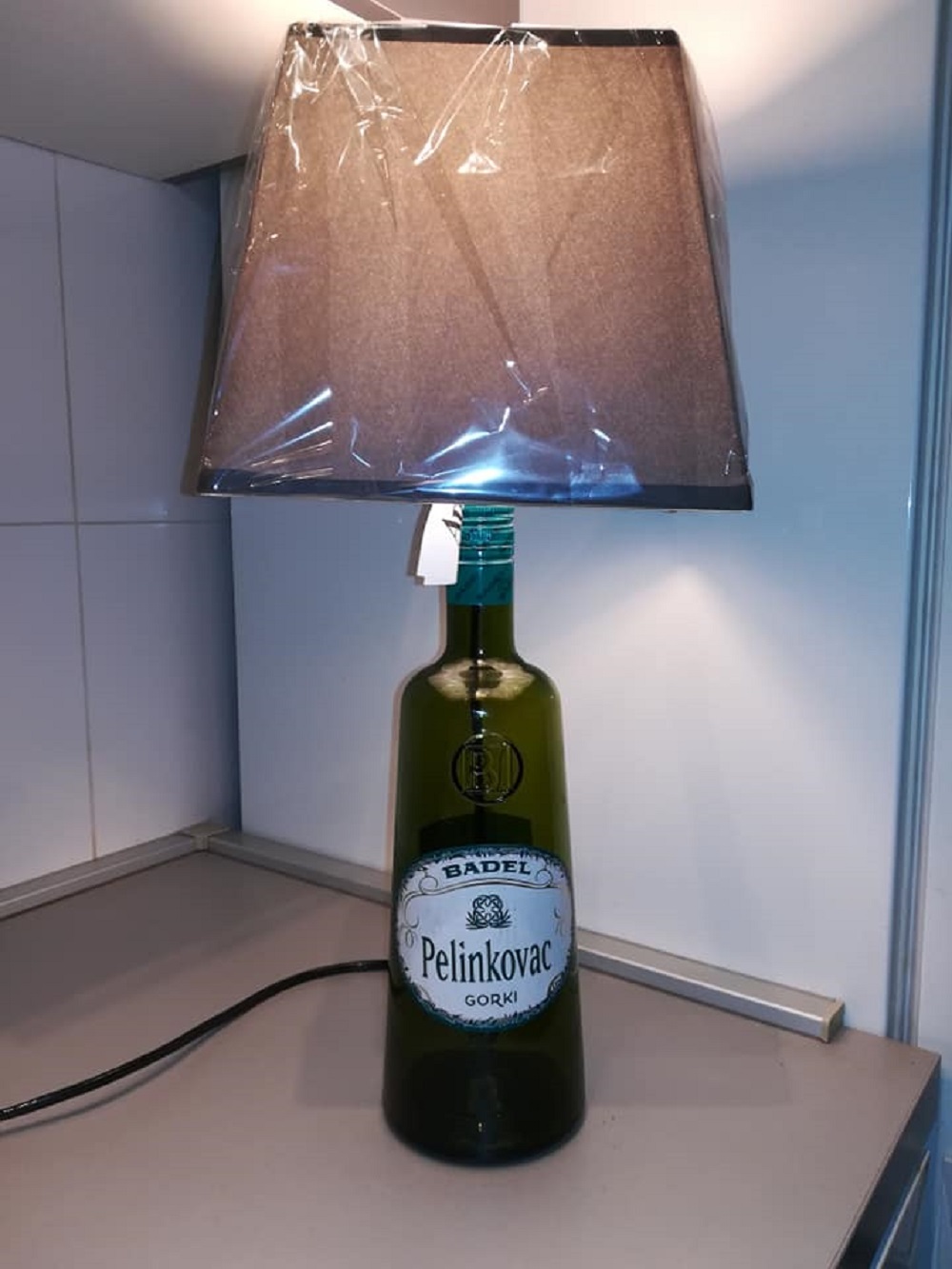 I ovo remek djelo: lampa od flaše Pelina; 150 kuna. 
<br>
<br>
Možete je pronaći na <a href="https://www.facebook.com/marketplace/item/200365274251088"><b>Facebook Marketplaceu</b></a>