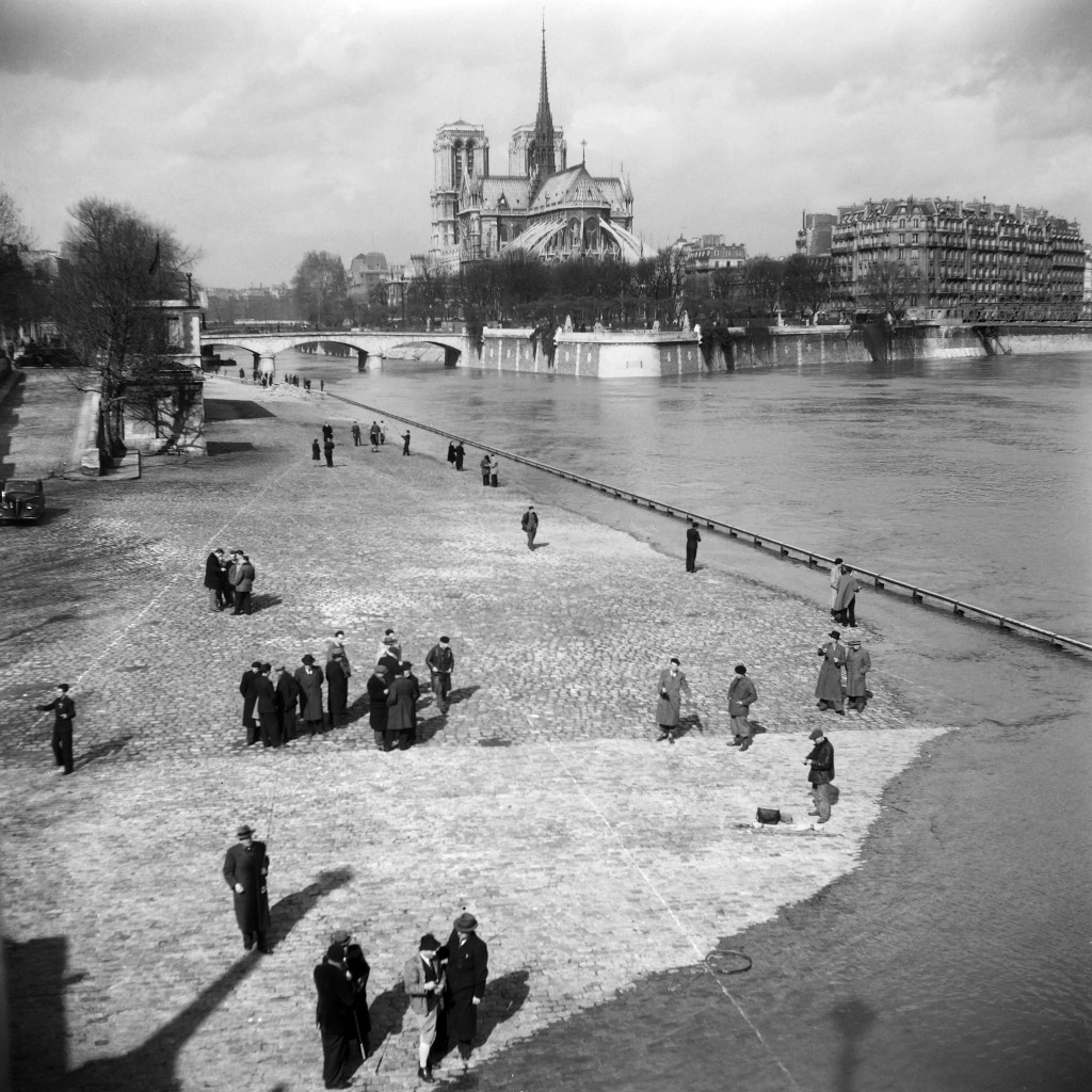  Parižani uživaju u šetnji obalom rijeke Seine pokraj otoka la Cite, jednog od najstarijih dijelova grada, u proljeće 1947. godine, kada je grad konačno oživio nakon rata i njemačke okupacije. U pozadini se vidi Notre-Dame. (Photo by - / AFP)