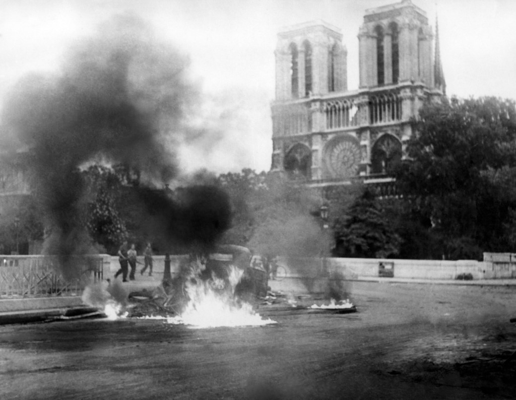 Fotografija je snimljena 24. kolovoza 1944. godine tijekom borbi za oslobođenje Pariza od Nijemaca i francuskih kolaboracionista. Na fotografiji se vidi vozilo zapaljeno u borbama, ali Notre-Dame u pozadini tom je prilikom izbjegla plamen.  (Photo by - / AFP)