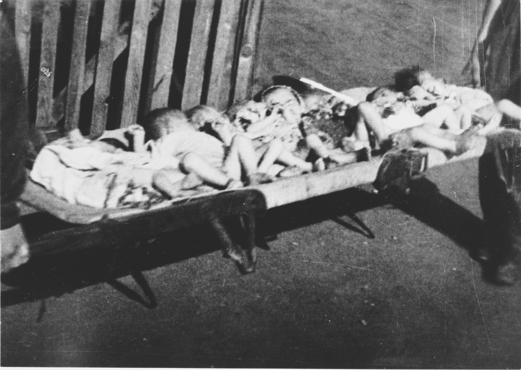 Preminula djeca leže na nosilima, prije nego što su ih zakopali u masovnu grobnicu unutar logora.