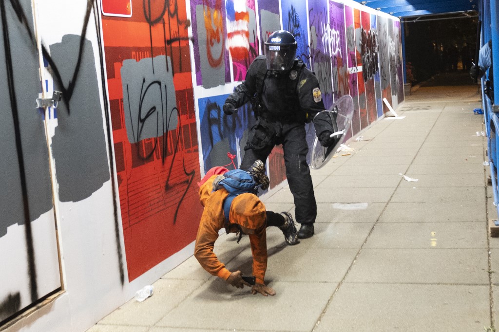 Policajac ruši jednog od prosvjednika na pod