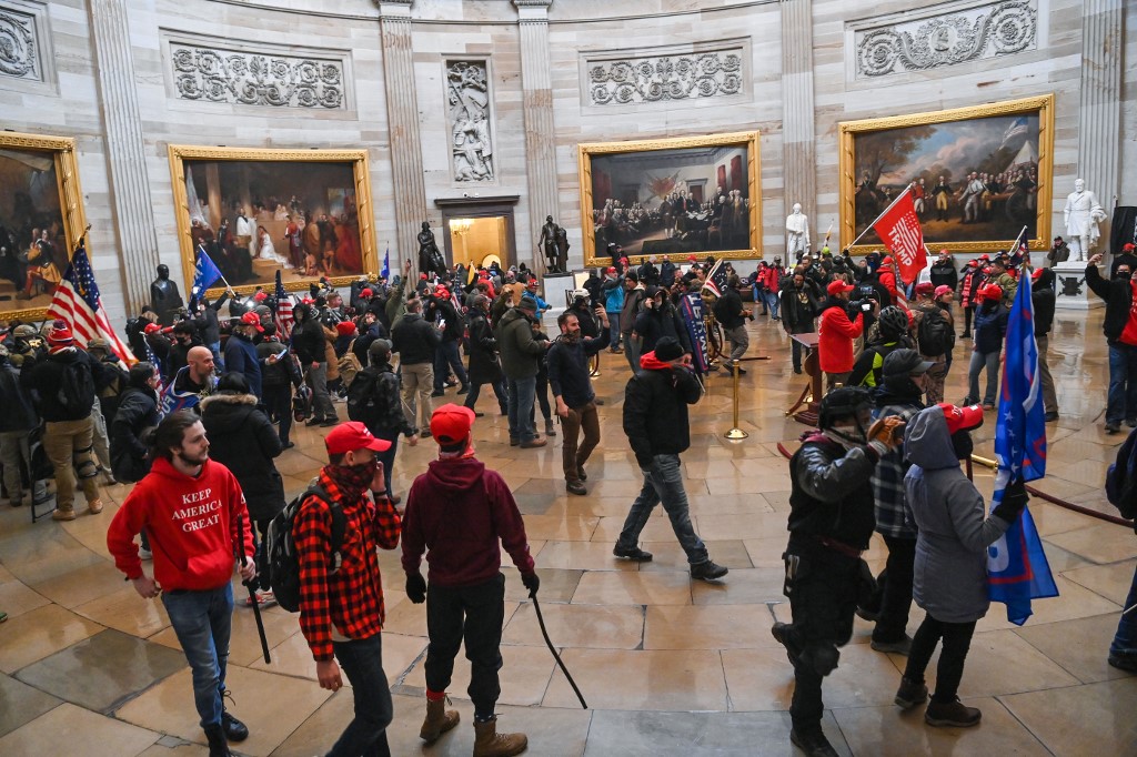 Supporters of US President Donald Trump roam under the Capitol Rotunda after invading the Capitol building on January 6, 2021, in Washington, DC. - Demonstrators breeched security and entered the Capitol as Congress debated the a 2020 presidential election Electoral Vote Certification. (Photo by Saul LOEB / AFP)