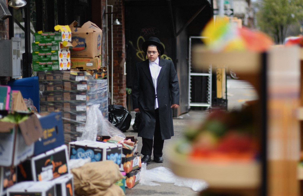 A member of the Orthodox Jewish community passes by a grocery store on April 8, 2020 in Brooklyn, New York, as the Passover holiday starts Wednesday evening and runs to April 16, 2020. - Churches will be empty this Easter and Passover festivities will also take place behind closed doors owing to the COVID-19 lockdown. Christians will be obliged to turn to services broadcast on television or over social media this year owing to the coronavirus and Jews will mark the Passover holiday in their own homes rather than as communities. (Photo by Angela Weiss / AFP)